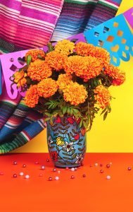 Day of the dead Dia De Los Muertos Celebration Background With marigolds or cempasuchil flowers in vase and papel picado decor. Bright orange and yellow copy space Traditional Mexican culture festival